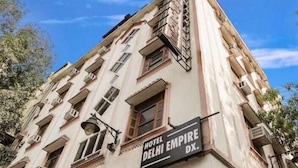 Un edificio de varios pisos con un letrero que dice "HOTEL DELHI EMPIRE DX".