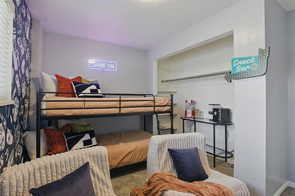 A dorm-style room with bunk beds, a desk with a computer, and a sign indicating a snack bar. - 1 min from Lindon Temple- Hot tub, Sleeps 16, Xbox, Poker, 6 Bed (Orem)