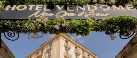 A hotel sign with the name 'HOTEL VENDOME' and a tagline 'Nice Casa di tutti'.