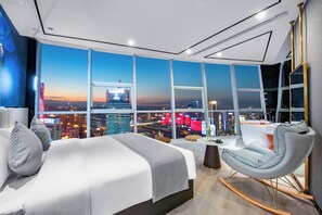 A modern hotel room with a large bed, a seating area, and a city view. - Fraya High - altitude Future Hotel (Chongqing)