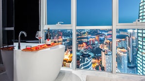 A modern bathroom with a large window offering a cityscape view at night. - Fraya High - altitude Future Hotel (Chongqing)