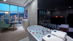 A modern bathroom with a bathtub, a green chair, and a city view. - Fraya High - altitude Future Hotel (Chongqing)