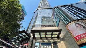A modern building with a glass facade and signage for 'Xinhua International'. - Fraya High - altitude Future Hotel (Chongqing)