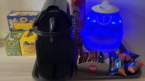 Een koffieapparaat, een waterdispenser en diverse etenswaren op een tafel.