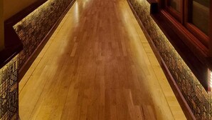 A long, narrow hallway with wooden flooring and decorative wall panels. - Boutique Hotel Grandview (Baku)