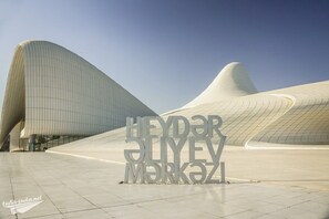 Una estructura arquitectónica moderna con un diseño curvo distintivo, con un letrero de texto destacado en primer plano.