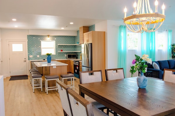 A modern kitchen with a central island, wooden cabinets, and a chandelier. - Blue Haven -Private Heated Pool, Hot tub, Spa, EV (Branson)
