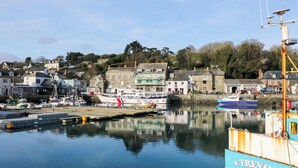 A harbor with boats docked, a building with a sign, and a clear sky. - Lodge 9 - Lamorna (Padstow)