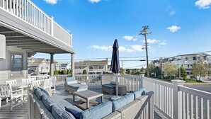 A covered outdoor deck with wicker furniture and a pergola. - Large 6 bedroom,7.5 bath house in Avalon, NJ-POOL  & Ocean Views- 3rd from beach (Avalon)