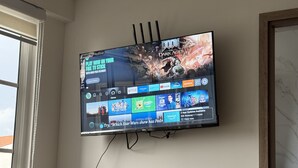 A flat-screen TV mounted on a wall displaying a video game.