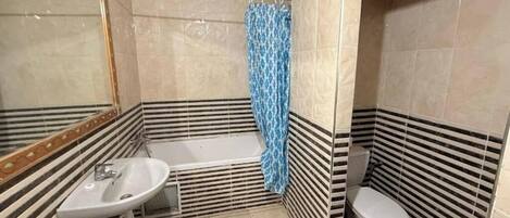 Ein Badezimmer mit einer Badewanne, Toilette und Waschbecken.