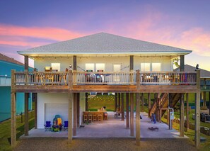 A two-story house with a balcony, a deck, and a play area.