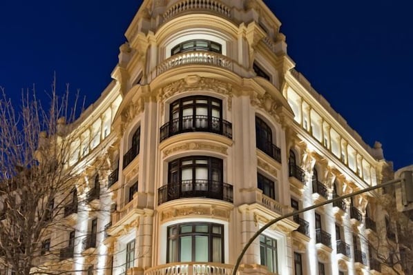 Un edificio de varios pisos con balcones, ventanas amplias y detalles arquitectónicos de estilo clásico.