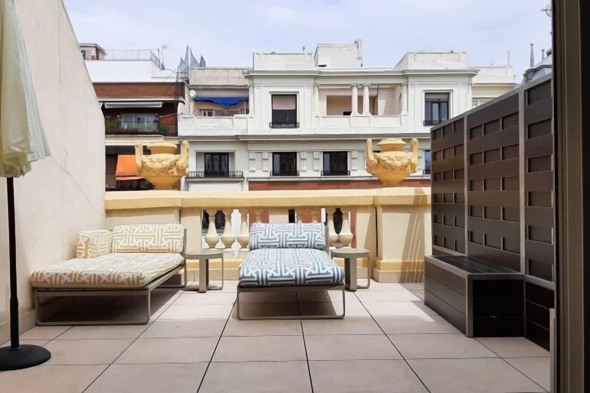 Un balcon avec deux canapés, une petite table et des vases décoratifs.