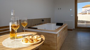 A modern bathroom with a bathtub, a wooden vanity, and a table with food and drinks. - OSTALEA Boutique Rural House with Jacuzzi, near the beach and medieval villages. (Vilanova d'Alcolea)