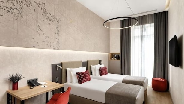 A modern hotel room with a large bed, a desk, a chair, a TV, and a map on the wall. - Hotel Vision Budapest by Continental Group (Budapest)