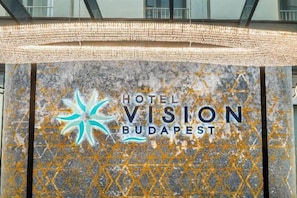 Skilt for Hotel Vision Budapest med en stjernelogo og hotellets navn.