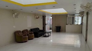 A spacious room with a high ceiling, recessed lighting, and a large window providing natural light. - Royal Comfort Homestay (Patna)