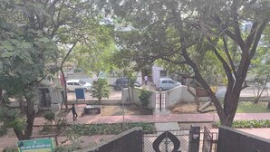 A gated entrance with a metal gate, a paved pathway, and a signboard. - Royal Comfort Homestay (Patna)