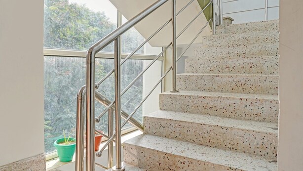 A staircase with metal railings and terrazzo steps, leading to an upper floor. - Royal Comfort Homestay (Patna)
