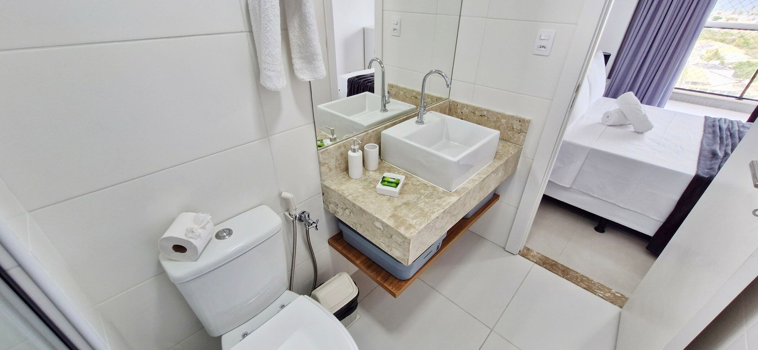 A modern bathroom with a toilet, bidet, and two sinks.