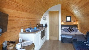 A compact, wooden interior with a kitchenette, a dining area, and a sleeping area. - Luna Holiday Pod - UK48590 (Snailbeach)