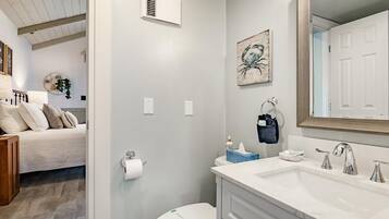 A bathroom with a white sink, a toilet, and a shower area.