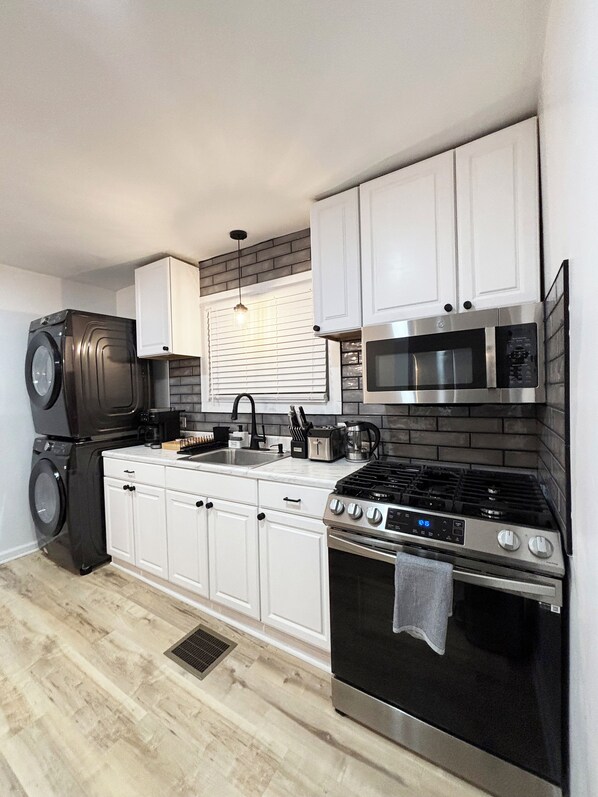 Effortlessly prepare meals in this well-equipped kitchen with a gas stove, microwave, and stainless steel range hood.