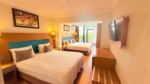 Habitación de hotel con dos camas, un cuadro en la pared, un televisor y vistas al exterior.