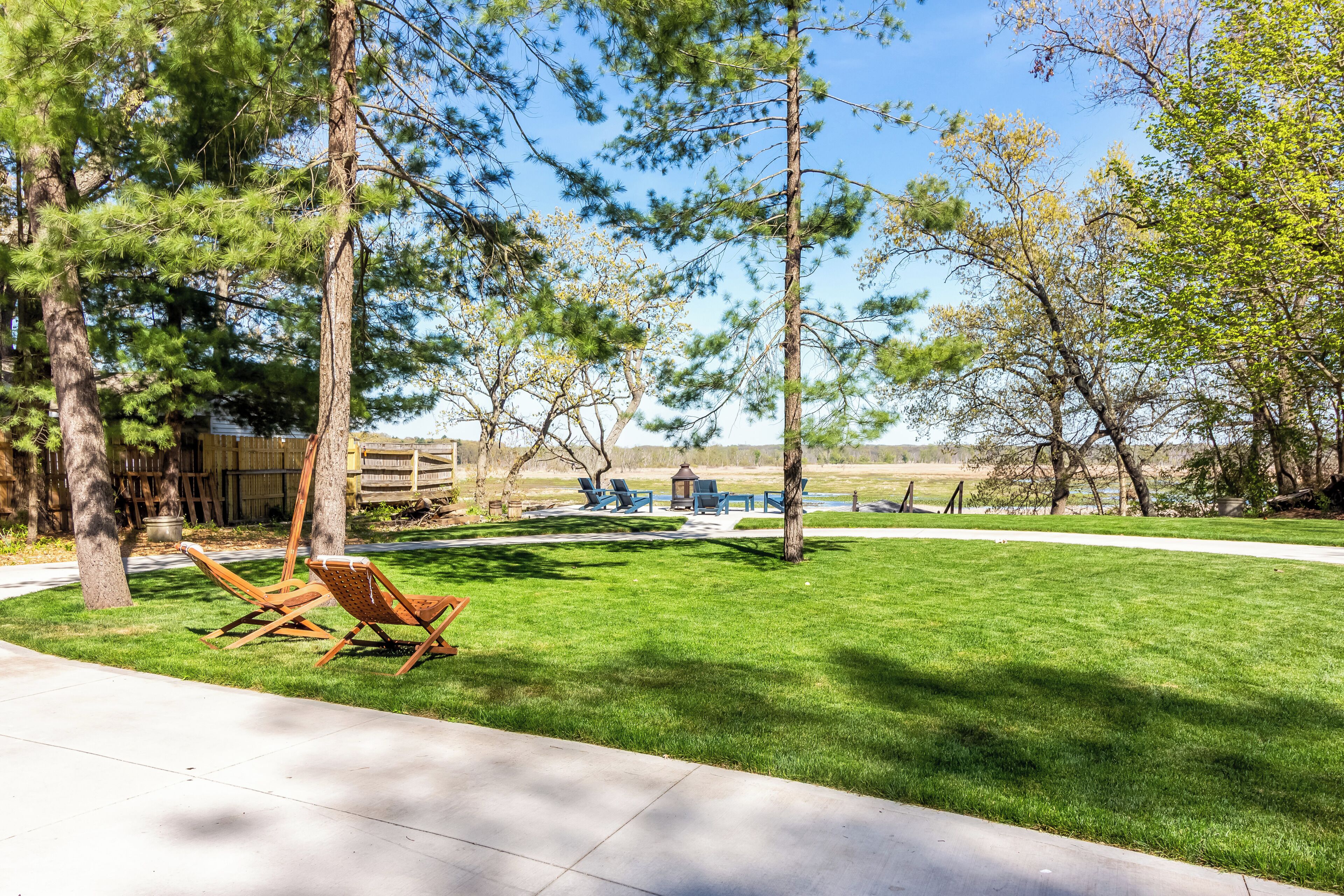 Ein Garten mit Rasen, zwei Holzstühlen und einer Holzterrasse.