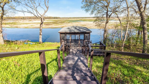 Une terrasse en bois menant à un belvédère situé au bord d’un lac.