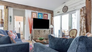 Un salon avec un canapé, un téléviseur et un mur décoratif.