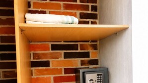 Un mobiletto angolare con ripiani e un cassetto, appoggiato a un muro in mattoni.