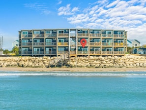 Un hotel de varios pisos con balcones, situado junto a la playa.