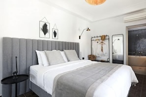 Ein modernes Schlafzimmer mit einem großen Bett, Nachttischen, einem Kleiderschrank und einem Fenster mit Blick.