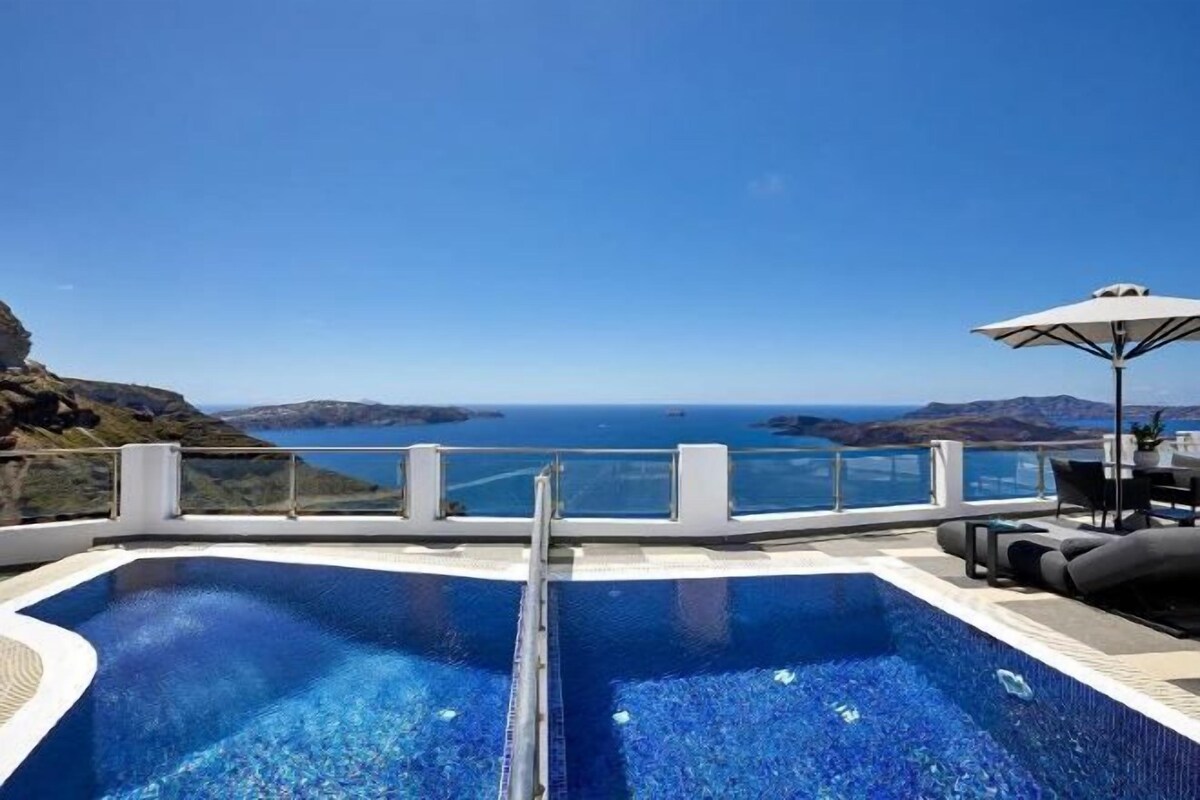 A swimming pool with a clear view of the sea and distant land.