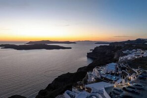 A coastal view with buildings and a body of water. - Petit Palace Suites (Santorini)