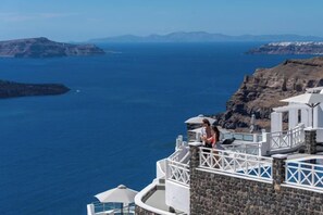 A seaside hotel with a view of the sea and cliffs. - Petit Palace Suites (Santorini)
