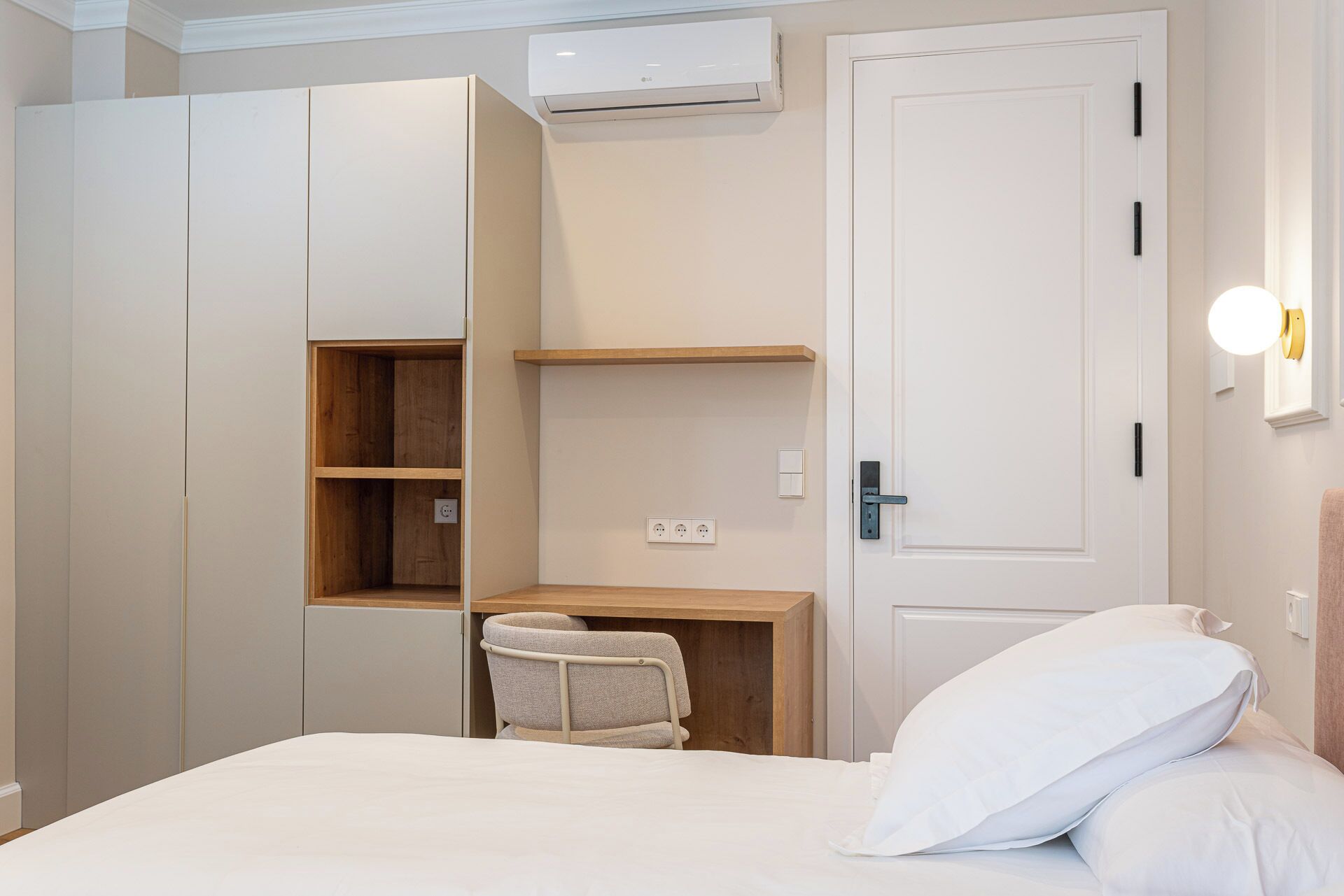 Un dormitorio con cama, escritorio y armario.