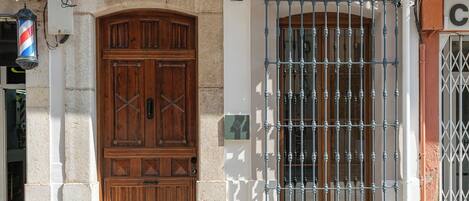 A building entrance with a wooden double door and a metal gate.