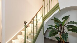 Un escalier avec des balustrades vertes et un mur blanc.