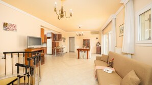 Un amplio espacio habitable con sofá, mesa de comedor y zona de cocina.