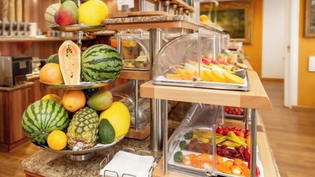 Disposição de buffet com diversas frutas e legumes.