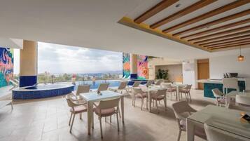 A rooftop terrace with a pool, lounge chairs, and a view of the city.