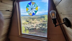 A skylight with a star-shaped stained glass window and a wall-mounted light fixture. - Pronghorn Point Cabin@22 West Cabins 18miles from Walden 80 miles from Steamboat (Walden)