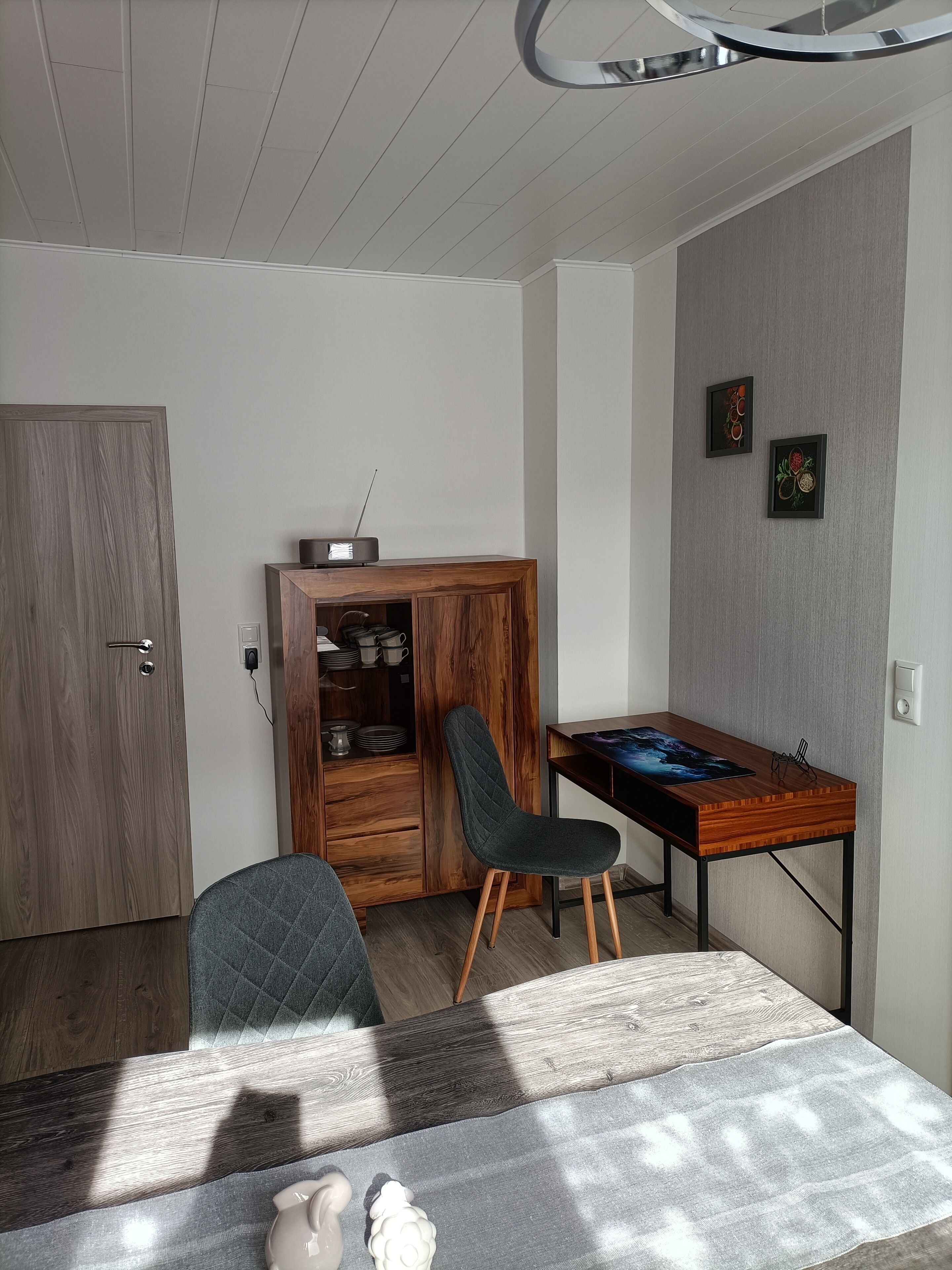 Ein modernes Zimmer mit einem Holzkoffer, einem Schreibtisch und einem Stuhl.