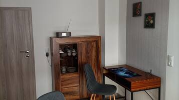 Ein modernes Zimmer mit einem Holzkoffer, einem Schreibtisch und einem Stuhl.