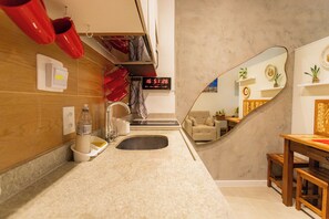 Features a sink, large mirror, and seating area with a table and bench.