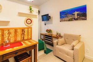 Relax in this stylish living room with a comfortable sofa, wooden bench, and flat-screen TV.