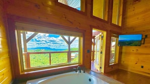 A wooden cabin with a large window offering a view of a green landscape. - New Amazing View Cabin, 5 miles to Dollywood, 12 miles to Smokies, Sleeps 11 (Sevierville)